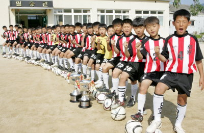 ▲ 소년체전에서 우승, 전국 정상급 실력을 확인한 화원초등학교 축구 선수들이 31일 학교 운동장에서 훈련하기 전 우승컵을 놓고 파이팅을 외치고 있다. 정우용기자vin@msnet.co.kr