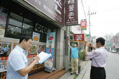 ▲ 부끄러운 간판 문화가 바뀔 수 있을지 관심이 모이고 있다. 사진은 수성구 조사원이 건물 간판들을 꼼꼼히 조사하는 모습.