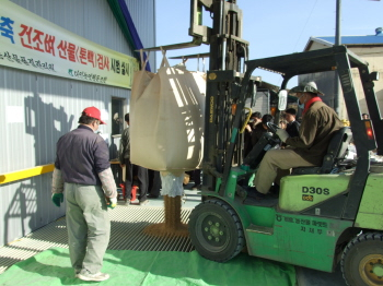 ▲ 22일 의성 다인농협 벼 건조저장시설에서 열린 공공비축미 톤백 검사 시연회에서 지게차가 톤백에 든 벼를 건조시설에 쏟아붓고 있다.