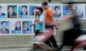 ▲ 6·4 재·보궐선거가 하루 앞으로 다가온 가운데 2일 오후 대구 서구 비산동의 한 주택가에서 유권자들이 서구청장 및 시의원 선거 벽보 앞을 무심히 지나고 있다. 이번 선거는 휴일이 아닌데다 사상 최저 투표율이 우려돼 선관위측이 투표율 높이기에 고심하고 있다. 김태형기자