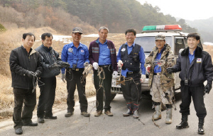 ▲ 올무수거에 나선 밀렵감시단원들이 수거한 올무와 덫을 들어보이고 있다.