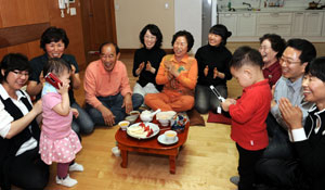 ▲ 안사돈, 두 딸 내외와 한 집에 사는 김기찬(75)·김난희(74)씨가 지난달 30일 외손자와 손녀의 재롱을 보며 즐거워하고 있다. 왼쪽 아래부터 시계반대 방향으로 둘째 며느리 최경숙(35), 맏딸 김정희(51), 김기찬, 맏며느리 정윤정(34), 김난희, 경숙씨의 딸 박한다(18), 사돈 이복순(72), 맏사위 박경남(52), 셋째딸 김미경(44)씨. 앞쪽에 손녀 김린(2)양과 외손자 오한결(2)군이 보인다. 성일권기자 sungig@msnet.co.kr