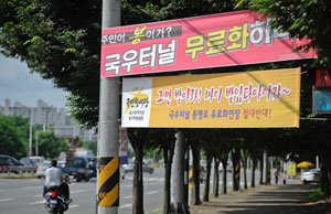 23일 오전 대구 북구 국우터널로 연결되는 서변동 도로에 국우터널 유료도로 무료화를 요구하는 주민들의 플래카드가 나붙어 있다. 우태욱기자 woo@msnet.co.kr