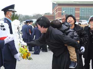 권성호 중령의 부인이 잠이 든 아들을 등에 업고 고인의 영정을 어루만지며 오열하고 있다.