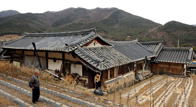 포항시 북구 기북면 오덕리 사우정(四友亭) 고택 뒤안. 고택을 관리하는 여강 이씨 11대손 이희국(83) 씨 부부가 조선시대 부인이 안방과 인접한 부엌 뒷문으로 바깥 출입하는 모습을 보여주고 있다. 이 씨는 