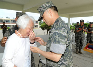 29일 오빠인 고 정형모 해병 소위의 무공훈장을 대신 목에 건 정옥희 할머니가 울음을 터뜨리고 있다. 해병대 제공