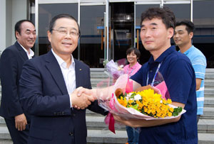 남유진 구미시장과 임춘구 구미시의회 의장이 삼성전자 구미 스마트시티로 출근한 삼성메디슨 구미제조센터 임직원들에게 환영의 꽃다발을 전하고 있다. 구미시 제공.