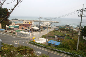 마을 한가운데 바다 쪽으로 난 복개도로를 따라 왼쪽은 경주시 양남면 지경마을, 오른쪽은 울산시 북구 강동동 신명마을이다.