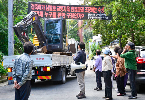 1일 오전 대구 수성구 만촌동 두봉마을 주민들이 굴착기를 싣고 와 공사를 시도하려는 건설업체의 화물차량 진입을 막고 있다. 우태욱기자 woo@msnet.co.kr