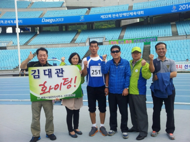 (사진) 2일 대구스타디움에서 열린 제33회 전국장애인체전 육상 경기에서 금메달 2개를 목에 건 김대관(왼쪽 3번째) 씨가 응원 온 대구시민운동장 관리사무소 직원들과 함께 포즈를 취하고 있다. 대구시민운동장 관리사무소 제공