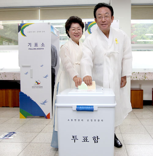 김관용 새누리당 경북도지사 후보가 부인 김춘희 씨와 함께 4일 오전 9시 구미 고아읍 문장초교를 찾아 투표를 하고 있다. 김 후보측 제공