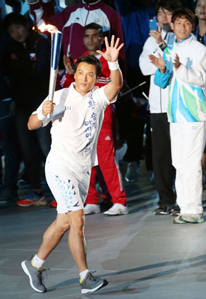 이승엽이 19일 인천 아시아드주경기장에서 열린 인천 아시안게임 개회식 성화봉송 주자로 나서 뛰어가며 인사하고 있다. 연합뉴스