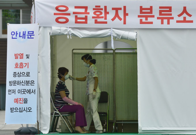 8일 대구의료원 감염관리센터 입구에 설치된 응급 환자 분류소에서 의료진이 방문자의 열을 측정하고 있다. 대구시는 시민 혼란과 대학병원 피해를 줄이기 위해 대구지역에서 발생하는 메르스 환자의 격리 치료 병원을 대구의료원 한곳으로 단일화했다. 우태욱 기자 woo@msnet.co.kr