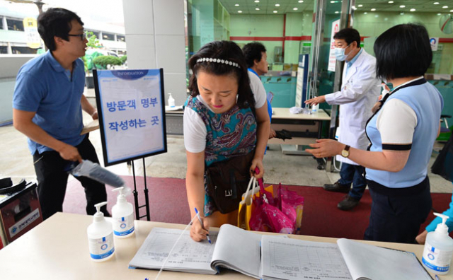 메르스 여파로 한국식 병문안 문화가 바뀌고 있다. 7일 오후 경북대병원 외래진료동 출입구에서 입원환자 면회객들이 방문객 명부에 이름과 생년월일, 휴대폰 번호 등을 기록하고 있다. 정운철 기자 woon@msnet.co.kr