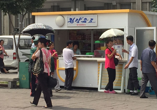 경기도 군사분계선에서 교전이 일어나고 이틀이 지난 22일 오전 평양역 광장 매점에서 남녀가 아이스크림을 먹으며 활짝 웃고 있다. 연합뉴스