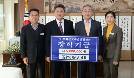 경북도 퇴직 공무원인 권덕희(왼쪽에서 세 번째) 씨가 봉화군청을 방문, 장학금을 전달했다.