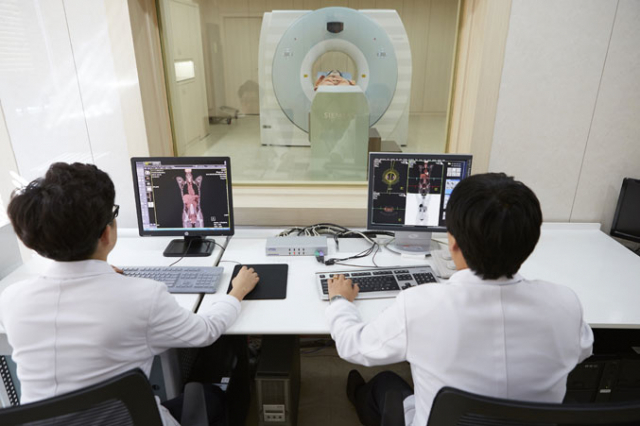 의료진이 PET-CT(조기 암검진) 장비로 모니터를 체크하고 있다.