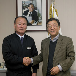 오연천 울산대 총장이 70세의 나이에 직장생활을 마감하는 정정모(왼쪽) 전 경비대장을 격려하고 있다. 울산대 제공.