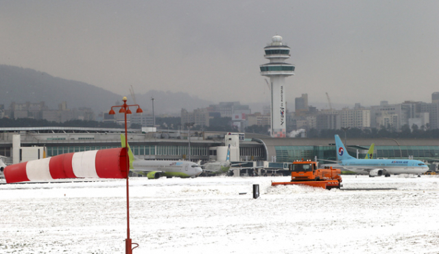 사상 초유의 제주공항 항공기 중단 사태가 3일째 이어진 25일 운항재개 결정이 내려진 가운데 활주로에서 제설작업이 이뤄지고 있다. 연합뉴스