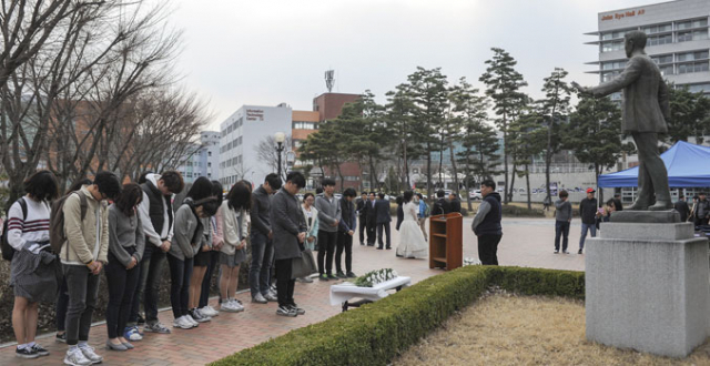 23일 대구가톨릭대에서 열린 안중근 의사 순국 106주기 추모식에 참석한 학생들이 헌화한 뒤 묵념하고 있다. 대구가톨릭대 제공