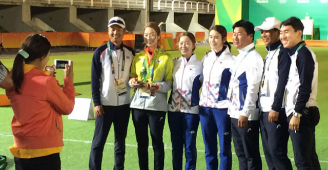 12일 리우 올림픽 여자 양궁 개인전이 끝난 뒤 장혜진, 기보배가 최미선을 위로하며 메달을 목에 걸어준 뒤 코칭스태프와 함께 기념사진을 찍고 있다. 채정민 기자 cwolf@msnet.co.kr