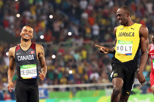 자메이카의 우사인 볼트가 18일 열린 리우 올림픽 육상 남자 200m 준결선에서 1위로 골인하며 전력 질주로 추격한 안드레 드 그라세(캐나다)를 보며 웃고 있다. 연합뉴스