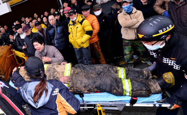 30일 오전 2시 8분게 대구 서문시장 강가 내 1지구와 4지구 사이에서 화재가 발생. 한 소방관의 아내가 절규하며 건물 붕괴로 부상을 입고 이송되는 소방관의 얼굴을 확인하고 있다. 김영진 기자 kyjmaeil@msnet.co.kr