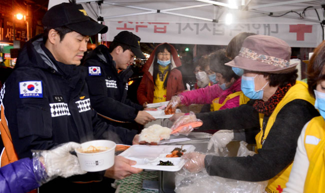 2일 서문시장 화재현장에서 대한적십자사 자원봉사자들이 저녁 식사 배식 봉사를 하고 있다. 김영진 기자 kyjmaeil@msnet.co.kr