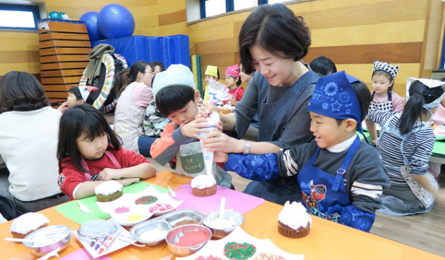 김애경 DGB금융그룹부인회봉사단 회장이 지난 19일 대구 북구 동광어린이집에서 아이들과 함께 성탄 케이크를 만들며 즐거운 시간을 보내고 있다. DGB대구은행 제공