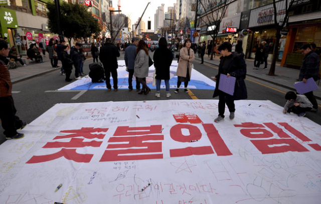 헌법재판소의 탄핵심판 선고가 임박한 4일 오후 대구 중앙로 대중교통전용지구에서 6천여 명의 시민들이 참가한 가운데 박근혜 퇴진 촉구 시국대회가 열렸다. 참가자들이 대형 걸개 그림에 헌재의 탄핵 인용에 대한 기대감을 나타내는 문구를 적고 있다. 우태욱 기자 woo@msnet.co.kr