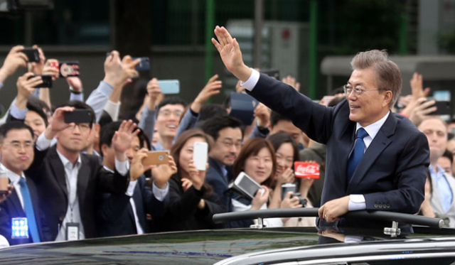 10일 오후 국회에서 취임식을 마친 문재인 대통령이 청와대로 향하다 광화문 네거리 부근에서 대통령 전용차량 위로 몸을 내밀어 환영하는 시민들에게 손을 흔들며 인사하고 있다.연합뉴스