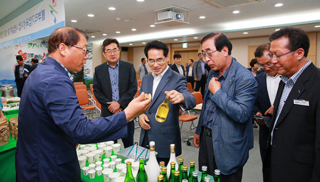 임광원 울진군수가 금강소나무와 해수를 활용한 전통주를 들고 제품 대중화에 대한 이야기를 나누고 있다. 울진군 제공