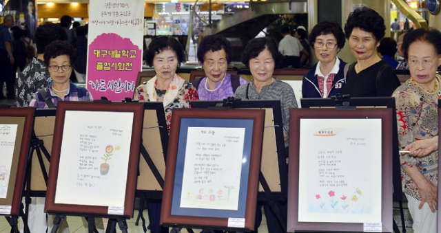 만학도 학교인 대구내일학교의 졸업시화전이 1일 대구 반월당역 메트로센터광장에서 열려 늦깎이 학생들과 시민들이 작품을 감상하고 있다. 성일권 기자 sungig@msnet.co.kr