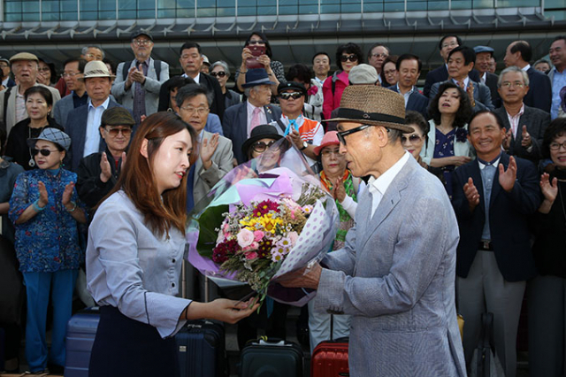 경주시 문화예술과 직원이 12일 경주에 도착한 제3회 세계한글작가대회 참가자를 대표해 고은 시인에게 환영의 꽃다발을 전달하고 있다. 경주시 제공