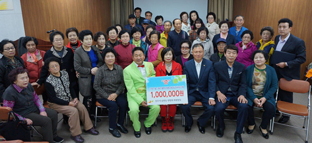 이상수 이경자(가운데 무대의상) 듀엣 강사가 노인을 위해 재능기부로 노래교실 6개월 연장을 결정하고 나서 참석주민들과 기념촬영을 하고 있다. 상주시 제공