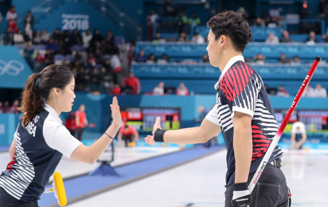 2018 평창올림픽 개막을 하루 앞둔 8일 오전 강릉컬링센터에서 열린 컬링 믹스더블(혼성 2인조) 예선 1차전 한국 대 핀란드 경기에서 장혜지와 이기정이 스톤을 티라인에 붙인 뒤 하이파이브를 하고 있다. 연합뉴스