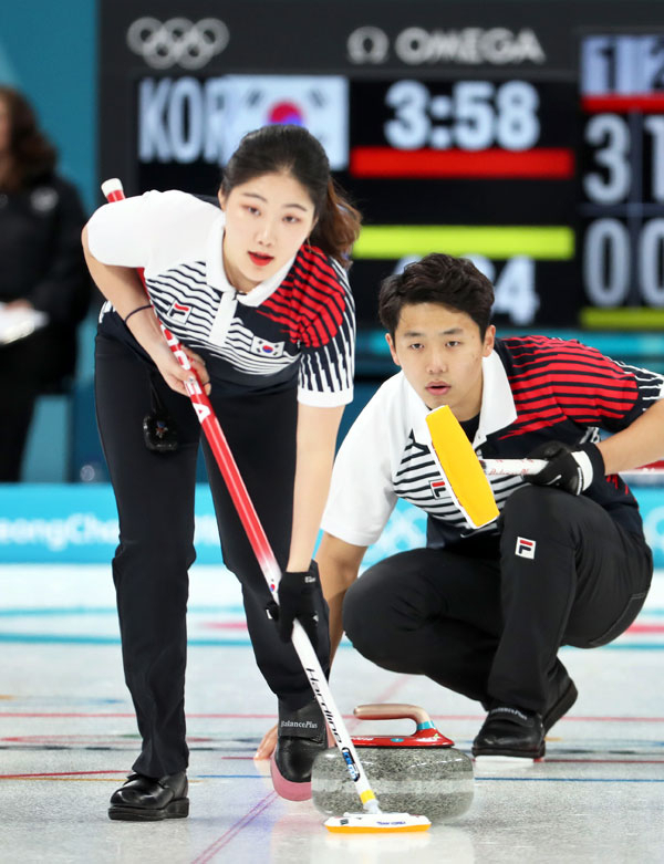 2018 평창동계올림픽 개막을 하루 앞둔 8일 오전 강릉컬링센터에서 열린 컬링 믹스더블(혼성 2인조) 예선 1차전 한국 대 핀란드 경기에서 첫승을 따낸 한국 이기정(오른쪽)이 표적을 향해 던진 스톤을 장혜지가 스위핑하고 있다. 연합뉴스