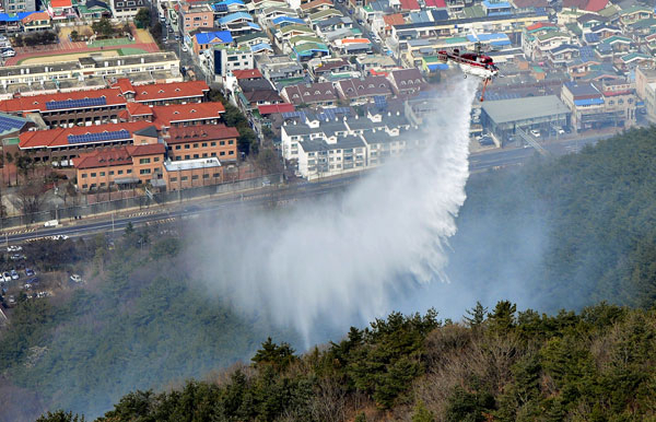 21일 오후 1시 40분쯤 대구 남구 남부도서관 뒤편 앞산 5부 능선에서 산불이 발생해 소방헬기가 진화작업을 벌이고 있다. 성일권 기자 sungig@msnet.co.kr