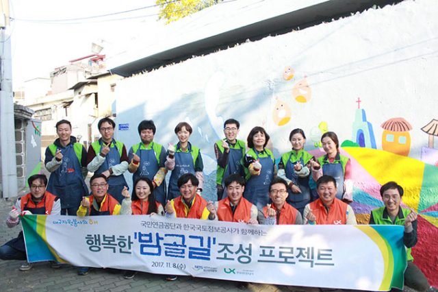 한국국토정보공사 대구경북지역본부와 국민연금공단 대구지역본부 직원들이 함께 벽화 그리기 봉사활동을 하고 있는 모습.한국국토정보공사 대구경북지역본부 제공