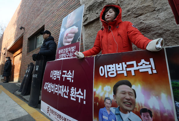 검찰이 100억원대 뇌물수수 의혹을 받는 이명박 전 대통령에게 소환조사 일시를 통보한 6일 서울 강남구 논현동 이 전 대통령의 자택 앞에서 민중민주당 당원이 구속을 촉구하는 1인 시위를 하고 있다 있다. 2018.3.6 연합뉴스