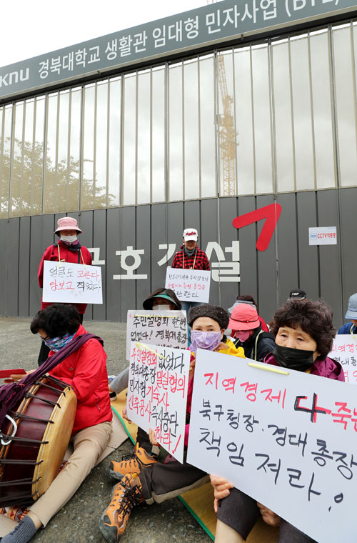 8일 경북대학교 인근 원룸 임대업자들이 경북대 기숙사 신축공사장 앞에서 건립 중단을 촉구하고 있다. 이들은 1천200여 명을 수용하는 기숙사가 들어서면 생존권이 위협받는다고 주장하고 있으나 학교 측은 