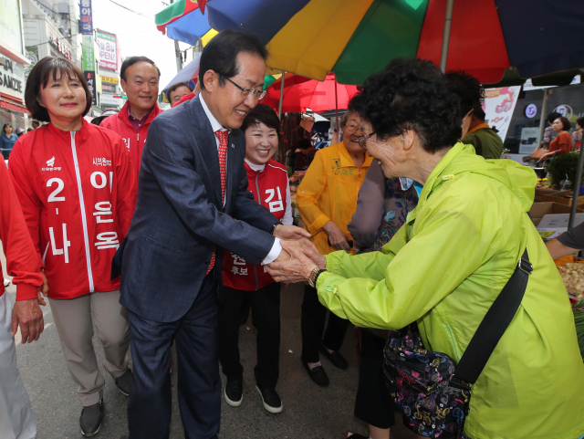 홍준표 자유한국당 대표가 29일 오후 강원도 원주시 중앙시장을 방문해 시민과 인사하고 있다. 연합뉴스