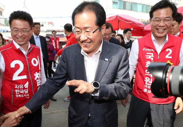 자유한국당 홍준표 대표가 30일 오후 이철우 경북도지사 후보(왼쪽), 송언석 김천시 국회의원 후보와 함께 경북 김천시 황금시장을 방문해 시민들과 인사하고 있다. 연합뉴스