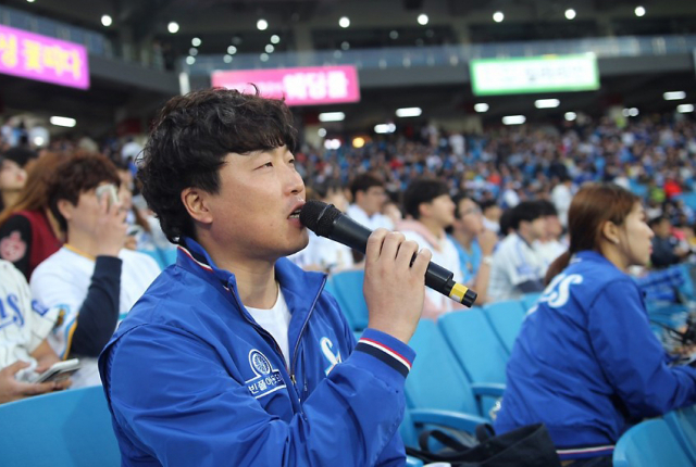 장내 아나운서 김용일 씨가 삼성라이온즈 경기 중 관중석에 앉아 방송을 하고 있다. 김용일 씨 제공