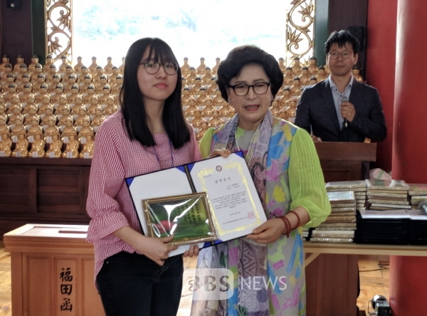 류병선 보광명문화장학재단 이사장이 학생에게 장학금을 전달하고 기념사진을 찍고 있다. 보광명문화재단 제공