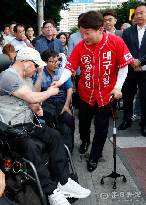 선거운동 중 부상을 당한 권영진 자유한국당 대구시장 후보가 2일 오후 대구 달서구 도원네거리 유세 현장에 지팡이를 짚고 나타나 지지자들과 악수를 하고 있다. 우태욱 기자 woo@msnet.co.kr