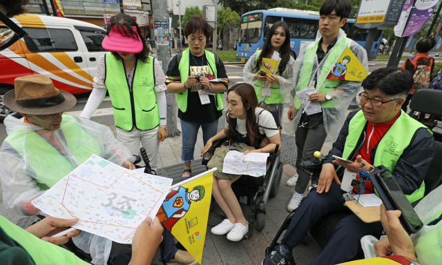 6일 오후 대구 동성로 일대에서 열린 커뮤니티매핑 참석자들이 휠체어 장애인 등의 이동권을 향상시키기 위해 휴대폰 어플리케이션을 이용해 주변 시설물 및 지리정보를 입력하고 있다. 김영진 기자 kymaeil@msnet.co.kr