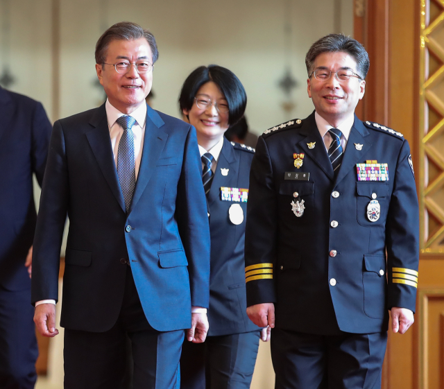 문재인 대통령이 24일 오후 청와대에서 민갑룡 신임 경찰청장에게 임명장을 수여한 뒤 간담회장으로 이동하고 있다. 연합뉴스