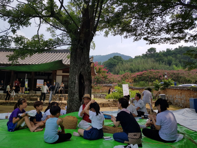 성주 월항면 한개마을 재실인 월봉정에서 열린 성주여씨향약 마을잔치가 있는 날 참가 어린이들이 마을 어른의 지도로 짚풀공예를 체험하고 있다. 성주군 제공