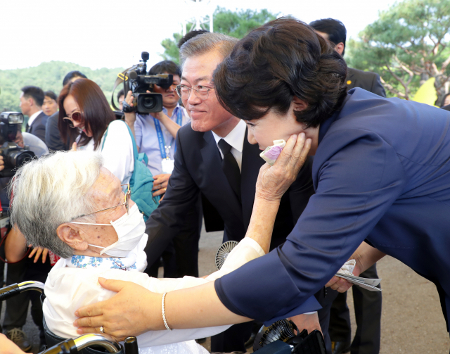 일본군 위안부 피해 생존자 김경애 할머니가 14일 충남 천안 국립 망향의 동산에서 열린 일본군 위안부 피해자 기림의 날 기념식이 끝난 뒤 김정숙 여사의 얼굴을 어루만지며 인사를 나누고 있다. 이번 기념식은 정부가 주관하는 첫 기념식으로, 기림의 날인 8월 14일은 일본군 위안부 피해자 고 김학순 할머니가 1991년 피해 사실을 처음 공개 증언한 날이다. 연합뉴스